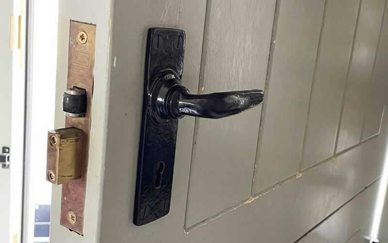 Black lever handle and mortice lock on a wooden door