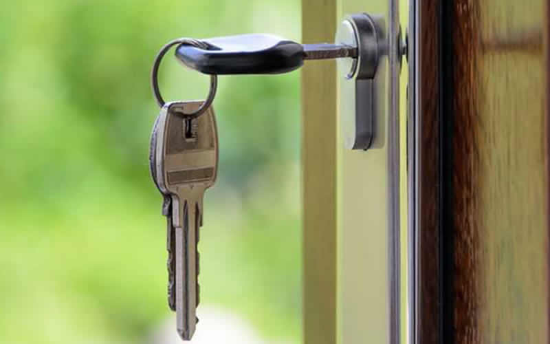 House keys hanging from a high-security euro cylinder lock in a front door